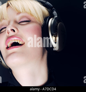 BLONDE AUGEN GESCHLOSSEN MIT KOPFHÖRER Stockfoto