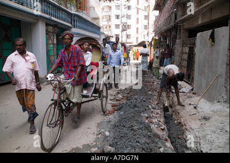 Rikscha-Puller Laufwerk übergeben einen Mann tun Straßenarbeiten in Dhaka Bangladesch Stockfoto