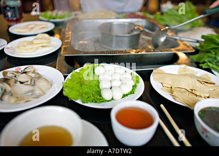 CHINA CHONGQING Zutaten für Chongqing Hotpot traditionelles Gericht serviert durch freundliche Bedienung Stockfoto