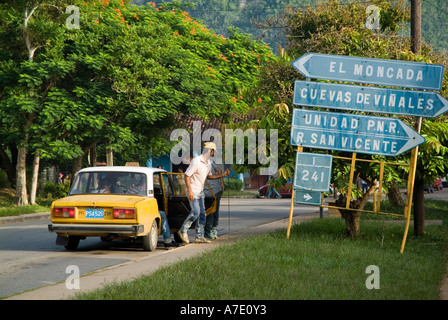 Kubaner, die immer aus einem Taxi in der Nähe Straße Zeichen in Vinales, Kuba. Stockfoto