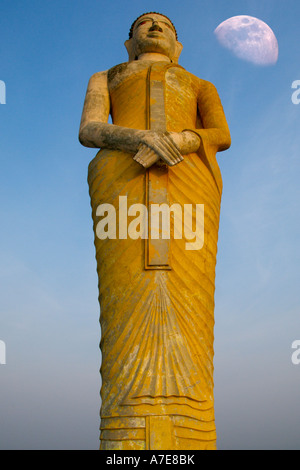 Eine Buddha-Statue im Wat Khao Tham Talu in Ratchaburi Provinz Thailand mit dem Mond im Hintergrund Stockfoto