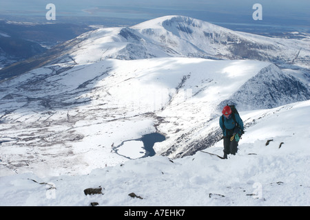 Ein Bergsteiger direkt unter dem Schnee bedeckt Gipfel des Snowdon den höchsten Berg in Wales-Snowdonia-Nationalpark. Stockfoto