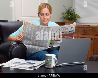 24 Jahr alt mexikanisch/weiße Frau sieht entmutigt, Suche nach Arbeitsplätzen in der LA Times. Stockfoto