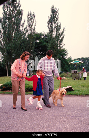 Familie, die ihren Hund im Park spazieren gehen Stockfoto