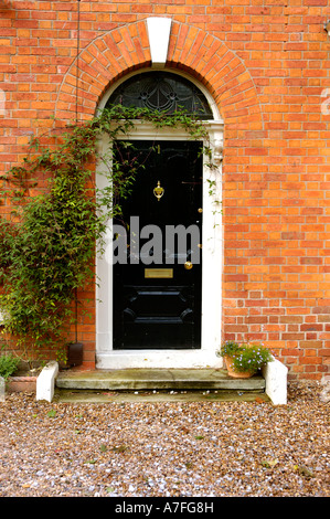 Schwarze Haustür EINES traditionellen georgischen Stil roten Ziegel British House mit EINEM Fanlight Fenster über der Tür Classic Englische Architektur Stockfoto