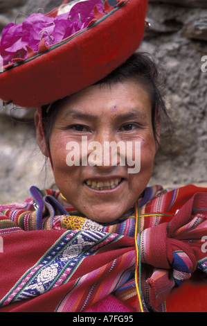 SA, Peru, Ollantavtambo, Portrait, peruanische Frau in rot mit Blütenblättern in Hut (MR) Stockfoto