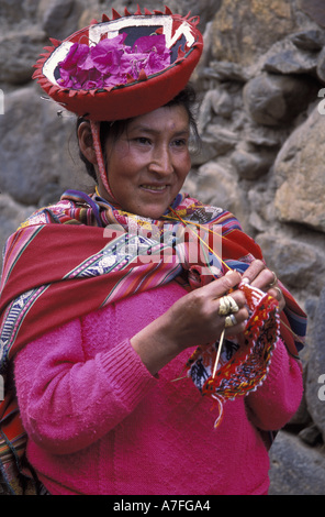 SA, Peru, Ollantaytambo, Porträt, peruanische Frau in rot mit Blütenblättern in Hut (MR) Stockfoto