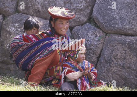 SA, Peru, Cusco peruanischen Mutter und Kinder auf dem Rasen durch die Felswand (MR) Stockfoto