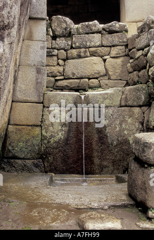 Südamerika, Peru, Machupicchu. Kleiner Wasser-Brunnen fließt in Inka Ruinen in Anden Berge hoch Stockfoto