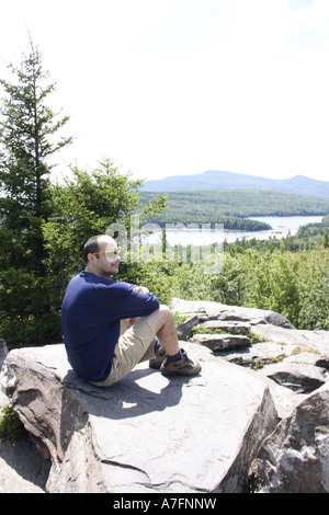 männliche Wanderer sitzen auf einem großen flachen Felsen Nord Süd See in den Catskill Mountains Stockfoto