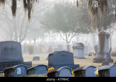 Grabsteine an nebligen Morgen im Friedhof Stockfoto