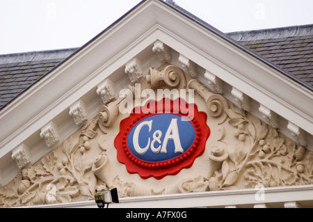 C Ein Schild der Bekleidungsfirma auf dem prunkvollen Portal eines klassischen Gebäudes in Leeuwarden, Friesland, Holland. Architektonische Details mit Steinschnitzereien. Stockfoto