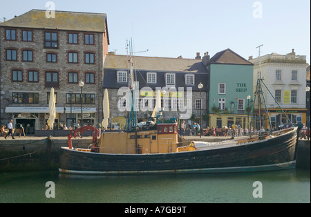 Bars entlang des Kais des Barbican mit einem alten Fischerboot gefesselt neben Plymouth Devon Great Britain Stockfoto