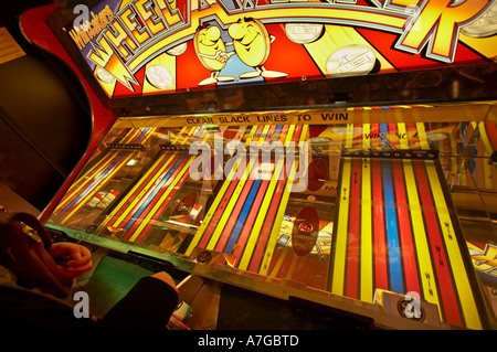 Person spielen Rollen eine Penny-Spiel in Spielhallen UK Stockfoto