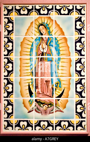 Keramikfliese der Heiligen Jungfrau Maria in Mexiko, Troppenmuseum, Amsterdam, Holland. Traditionelle religiöse Mosaikkunst mit Blumenrand. Stockfoto