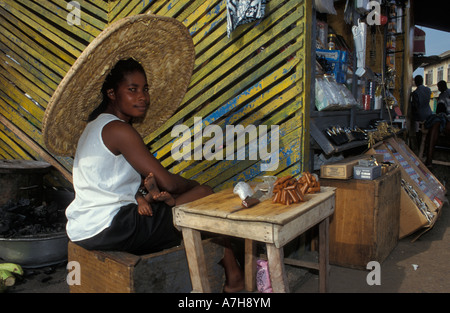 Frau trägt einen traditionellen großen Strohhut auf dem Markt Accra, Ghana Stockfoto