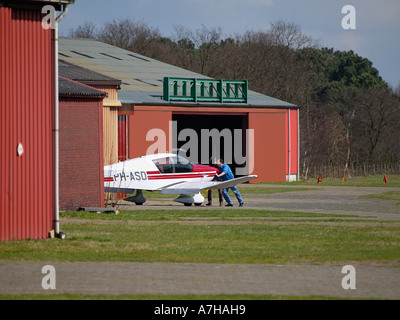 Zwei Männer drücken ihre kleinen Flugzeug in einem Hangar auf Seppe Flugplatz Noord Brabant, Niederlande Stockfoto