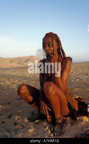 Himba Frau raucht eine traditionelle Rohr, Kunene-Region, Kaokoland, Namibia Stockfoto