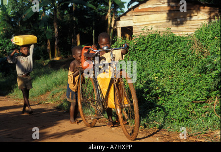 jungen, die Wasser aus dem Fluss zu bringen, in das Dorf in der Nähe von Jinja, Uganda Stockfoto