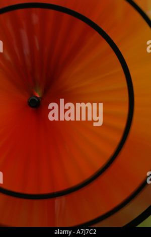 Eine orange Windmühle Spinner dreht in die Brise am Stanmer Park Brighton Stockfoto