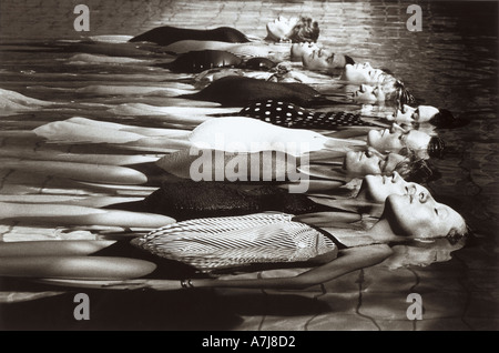 Junge schwangere schweben gelassen in einem Pool während einer Ante natal Übung Stockfoto