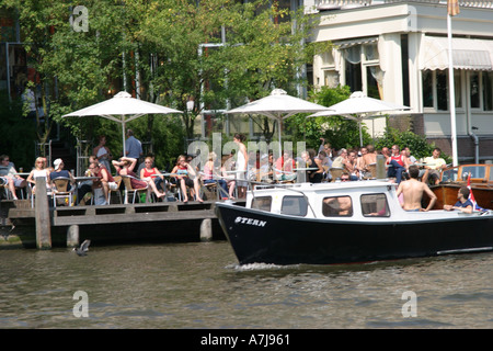 Boot Kreuzfahrt vorbei an einem Café auf dem Kanal in Amsterdam Niederlande Stockfoto