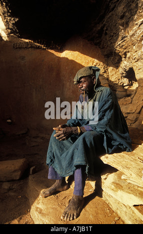 Hogon, geistige Führer raucht eine Pfeife in seinem geschnitzten Klippe, Ende Heimatdorf, Dogonland, Mali Stockfoto