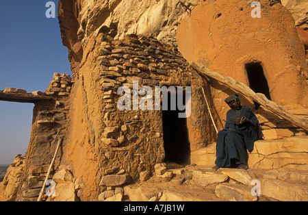 Hogon, geistige Führer raucht eine Pfeife in seinem geschnitzten Klippe, Ende Heimatdorf, Dogonland, Mali Stockfoto