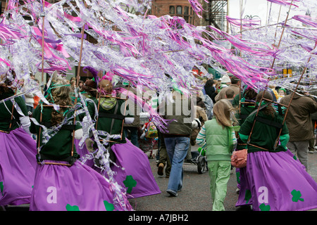 Parade-Goers wehenden bunte lila Bändern zu Fuß auf St Patricks Day Belfast Nordirland Stockfoto