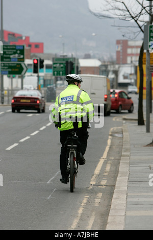 PSNI Polizist auf Mountainbike sieht auf die Seite hinunter Victoria Street auf St Patricks Day Belfast Nordirland Stockfoto