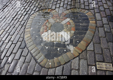 Heart of Midlothian inmitten nassen Kopfsteinpflaster auf der royal Mile mit spuckte Sie Kaugummi befestigt Edinburgh Schottland UK Stockfoto