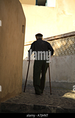 Alter Mann mit Walking-Stöcke um zu Fuß durch die Straßen von Santorini Griechenland Stockfoto