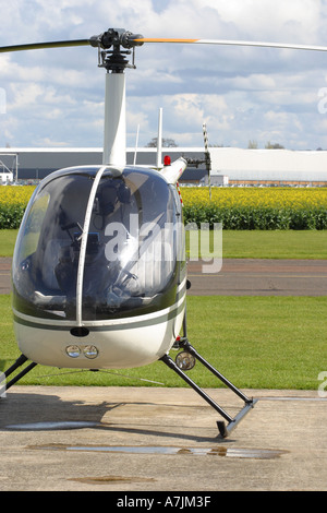 Privaten Helikopter geparkt auf kleine Hubschrauberlandeplatz England UK Robinson R22 Stockfoto