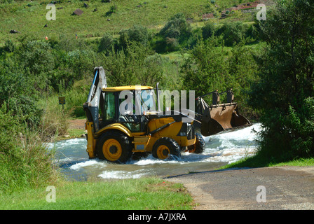 Gelben Volvo mechanischen Bagger Clearing Schutt von Mlambonja River bei Ford in der Nähe von Cathedral Peak Hotel Zulu Königreich Natal Stockfoto