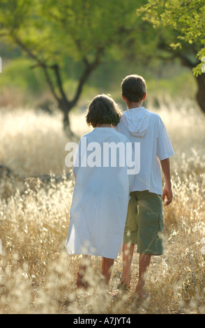 moderne Hänsel und Gretel, führt 11 Jahre alten kaukasischen junge seine neunjährige Schwester durch einen trockenen Bereich an einem heißen Sommernachmittag Stockfoto