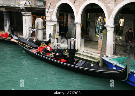 Touristen warten auf ihre Lustreise an einem Venedig-Kanal in einem typischen Gondel Boot, Venezia Italien europäisches Reiseziel EU Stockfoto