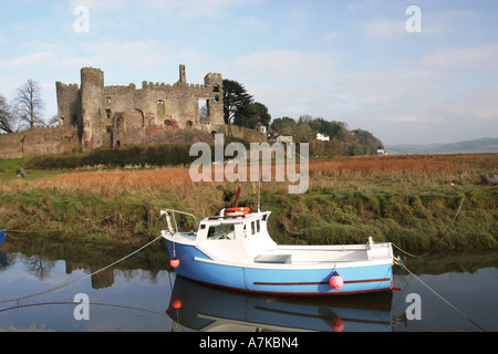 Kleines Fischerboot vor Anker auf der Taf-Esturay mit berühmten Laugharne Castle im Hintergrund, Carmarthenshire Wales UK Stockfoto