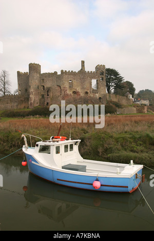 Kleines Fischerboot vor Anker auf der Taf-Esturay mit berühmten Laugharne Castle im Hintergrund, Carmarthenshire Wales UK Stockfoto