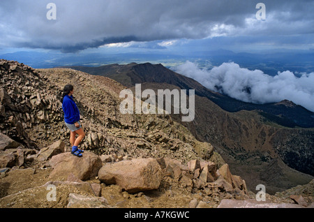 Weibliche Erwachsene Touristen am Pikes Peak betrachten Bergketten mit niedrigen Wolken Colorado USA Stockfoto