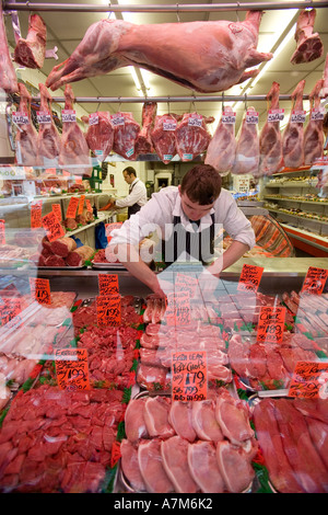 Ein Metzger ordnet eine Anzeige von Fleisch in die Schaufenster in Birmingham UK Stockfoto