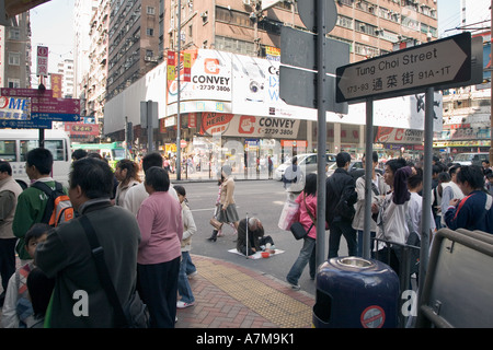 Belebten Kreuzung in Hong Kong mit einem Obdachlosen. Stockfoto