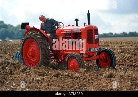 Eine altmodische Vintage arbeiten Traktor ein Feld pflügen Stockfoto