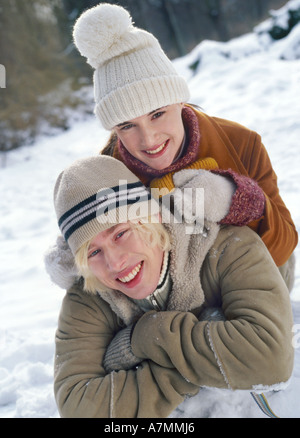 Junges Paar mit dem Schnee im Wald spielen. Stockfoto