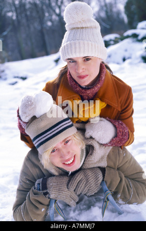 Junges Paar mit dem Schnee im Wald spielen. Stockfoto