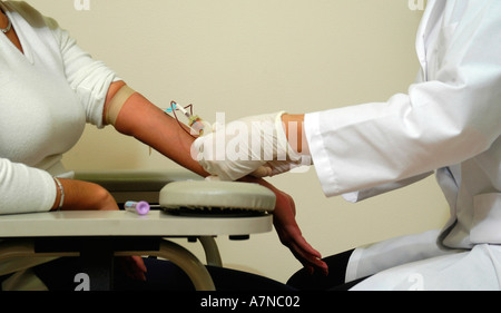 Nahaufnahme von einem Arzt Zeichnung Blut aus dem Arm einer Patientin zu Testzwecken Stockfoto