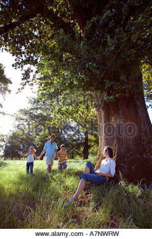 Eine Mutter mit ihren Kindern in der Frühlingssonne hand in hand gehen