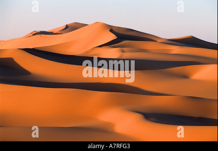 Libyen, Region der Wüste, Fezzan (Sahara), ockerfarbenen Dünen und hohen Leiste aus Sandstein des Tadrart Akacus im Nordosten von Ghat Stockfoto