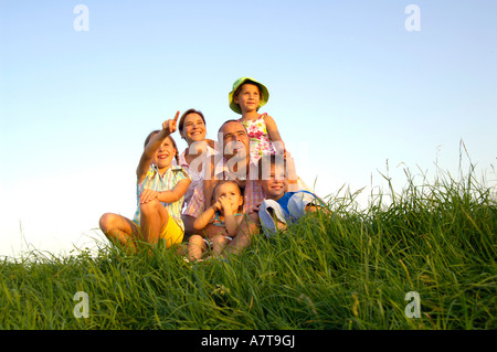 Familie sitzt im Feld Stockfoto