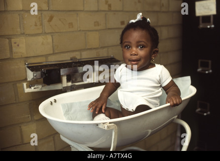 Afro Karibik Baby wird gewogen in einer Baby-Klinik Stockfoto