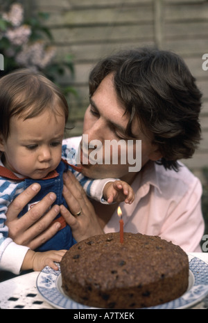 Ersten Geburtstag des Kindes mit Vater Kerze ausblasen Stockfoto